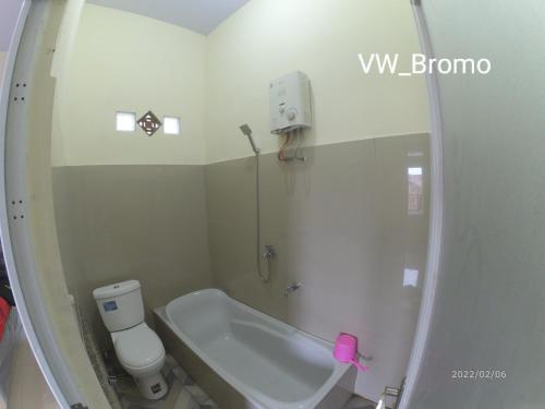 y baño con bañera, aseo y lavamanos. en wijayanti's villa en Probolinggo