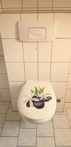 a white toilet with flowers on it in a bathroom at Villa Hoffnung in Bad Elster