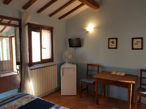 a room with a refrigerator and a table and a tv at Ca' le Suore in Cagli