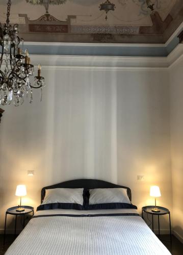 a bedroom with a bed with two lamps and a chandelier at BBCasablu in Acireale