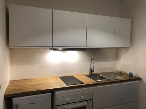 a kitchen with white cabinets and a sink at BBCasablu in Acireale