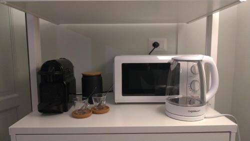 encimera de cocina con microondas y licuadora en La stanza di Camillo, en Roma