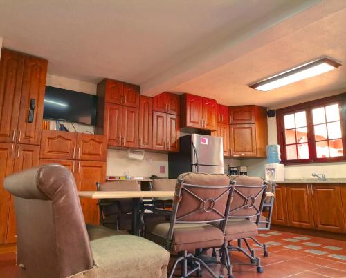 a kitchen with wooden cabinets and a table and chairs at Life Builders in Guatemala