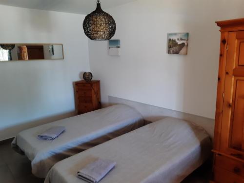 a room with two beds and a cabinet and a lamp at Quinta Cosy in Paderne