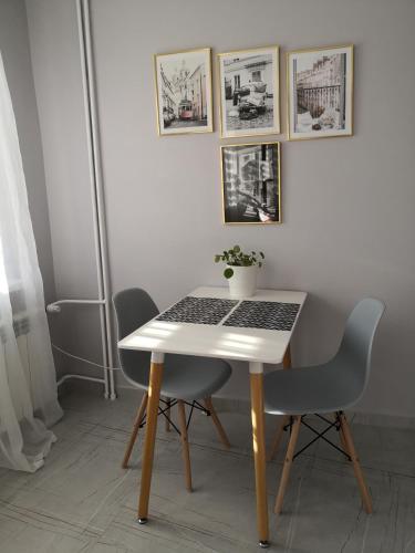 uma mesa branca com um computador portátil com duas cadeiras em Różowe sny em Klodzko