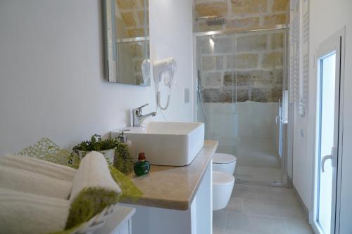 a white bathroom with a sink and a shower at La Naca dei Messapi Holiday Home in Mesagne