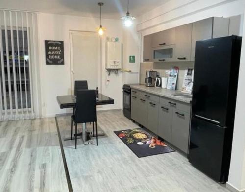 a kitchen with a table and a black refrigerator at Apartament de lux intr-o zona rezidentiala linistita in Iaşi