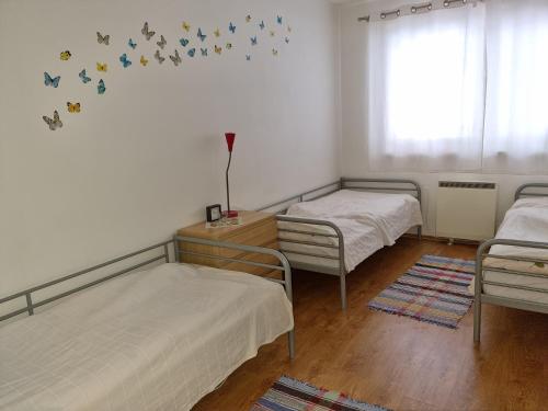 a room with two beds and a window with butterflies on the wall at Apartman pod Dedovkou in Oščadnica