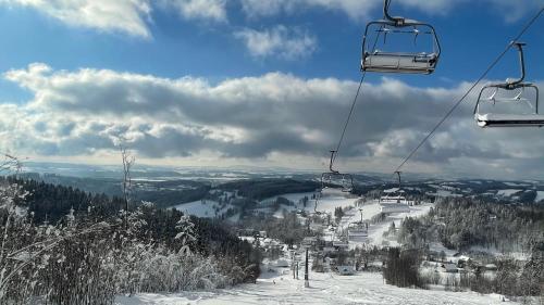 a ski lift on top of a snow covered mountain at CHATA POD HORAMA in Benecko