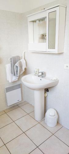 une salle de bain blanche avec un lavabo et un miroir dans l'établissement MENTON BORD DE MER Studio calme avec balcon, Ascenseur, Climatisation, Ideal location quiet near sea, balcony, elevator, AC, à Menton