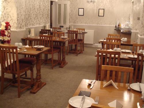 a dining room with wooden tables and chairs at The Fawley Guest house in Shanklin