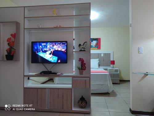 a living room with a tv in a entertainment center at Solar Pipa Praia Flats in Pipa