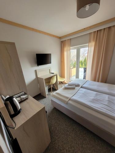 a hotel room with a bed and a desk at Karolowy pokoje&apartamenty in Ustroń