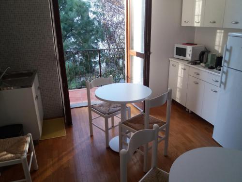 uma cozinha com uma mesa e cadeiras e uma cozinha com uma janela em I Pini B&B em Castagnito