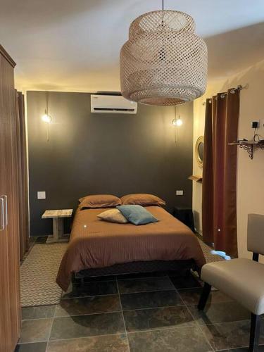 1 dormitorio con cama y lámpara de araña en Studio Urirama with swimmingpool en Noord