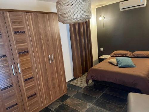 1 dormitorio con 1 cama y un gran armario de madera en Studio Urirama with swimmingpool en Noord