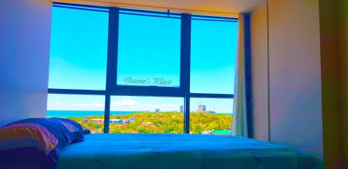 a bedroom with a window with a view of the ocean at Mactan Newtown - New Modern Condo with Ocean View in Mactan