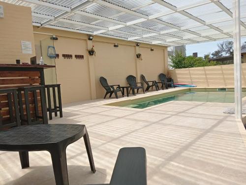 Un patio con sillas y una piscina. en DUPLEX AL SUR, en Villa Gesell