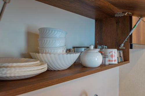 a shelf with plates and bowls and dishes on it at New Gudauri Apartment Loft 2 N332 in Gudauri