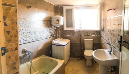 La salle de bains est pourvue d'une baignoire, de toilettes et d'un lavabo. dans l'établissement Midtown Homes, au Caire