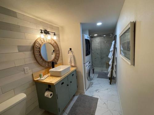 uma casa de banho com um lavatório, um espelho e uma banheira em Utah Valley Retreat - Luxurious Self check-in Apt, UVU BYU, EV Charge em Orem