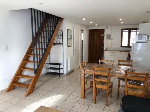une cuisine et une salle à manger avec une table et un escalier dans l'établissement Les Badalans, à Loudenvielle