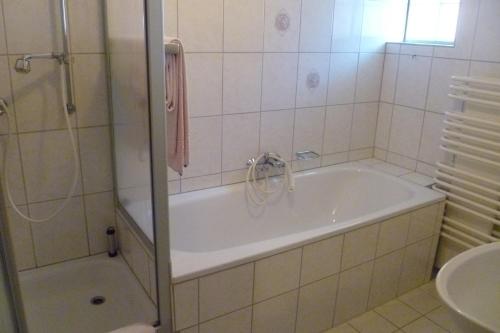 La salle de bains est pourvue d'une baignoire, d'une douche et d'un lavabo. dans l'établissement Gasthof Zwilling, à Schmallenberg