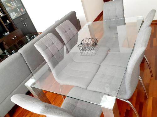 una mesa de cristal con dos sillas y un carrito de compras. en Hermoso Apartamento en el Centro de Trujillo, en Trujillo