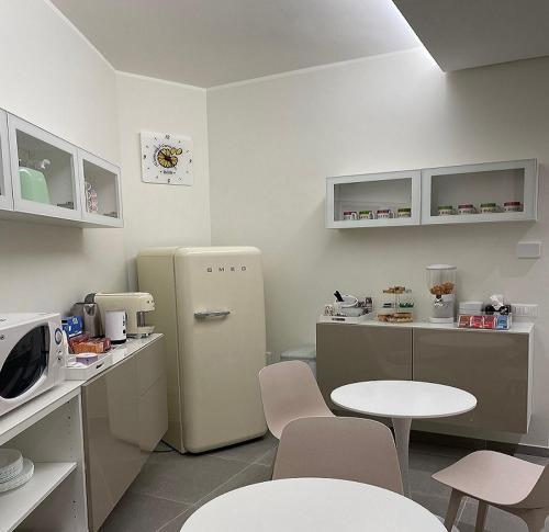 a kitchen with a refrigerator and a table and chairs at B&B m’ama non m’ama in Santeramo in Colle