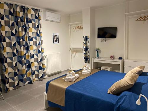 a bedroom with a blue bed with towels on it at B&B m’ama non m’ama in Santeramo in Colle