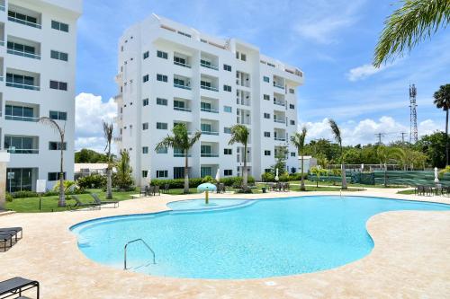 a swimming pool in front of a building at Apartamento en Juan Dolio Tepuy 501 B in Juan Pedro