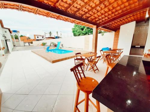 une terrasse avec des tables et des chaises ainsi qu'une piscine dans l'établissement Pousada Brilho dos Lençóis, à Barreirinhas