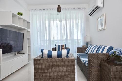 a living room with a couch and a television at Apartamento en Juan Dolio Tepuy 501 B in Juan Pedro