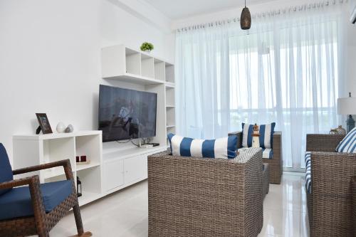 a living room with wicker chairs and a television at Apartamento en Juan Dolio Tepuy 501 B in Juan Pedro