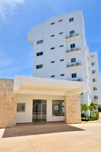 a large white building in front of a building at Apartamento en Juan Dolio Tepuy 501 B in Juan Pedro