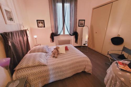 a teddy bear sitting on a bed in a bedroom at Beautiful apartment between St Rémy and Avignon in Châteaurenard