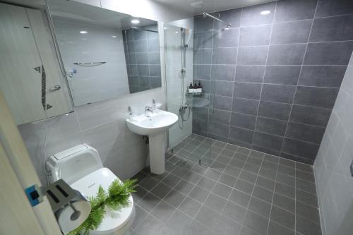 e bagno con servizi igienici, lavandino e doccia. di Hotel Marine a Pohang
