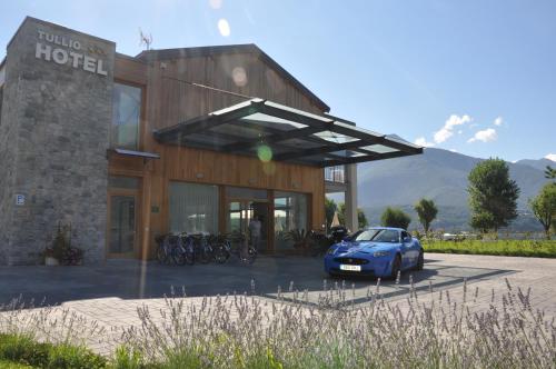 a blue car parked in front of a hotel at Tullio Hotel in Gravedona