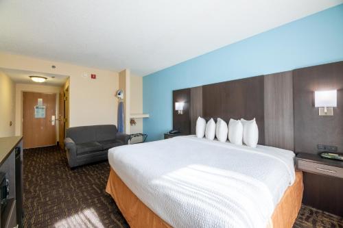 a hotel room with a large bed and a chair at River Bend Inn - Pigeon Forge in Pigeon Forge