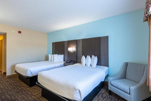 a hotel room with two beds and a chair at River Bend Inn - Pigeon Forge in Pigeon Forge