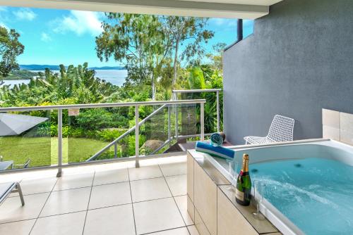 a bathroom with a tub with a view of the ocean at Blue Water Views Apartments in Hamilton Island