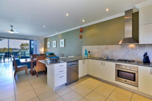 a kitchen with a table and a dining room at Blue Water Views Apartments in Hamilton Island