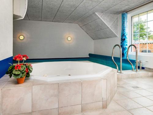 - dużą białą wannę w łazience z niebieskimi ścianami w obiekcie 10 person holiday home in Oksb l w mieście Øster Vrøgum