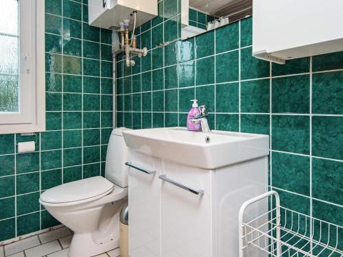 ヘンネ・ストランドにあるHoliday Home Hyttestienの緑のタイル張りのバスルーム(トイレ、シンク付)