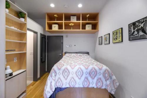 a small bedroom with a bed and shelves at Small Fully Equipped Contemporary Studio Near MGH in Boston