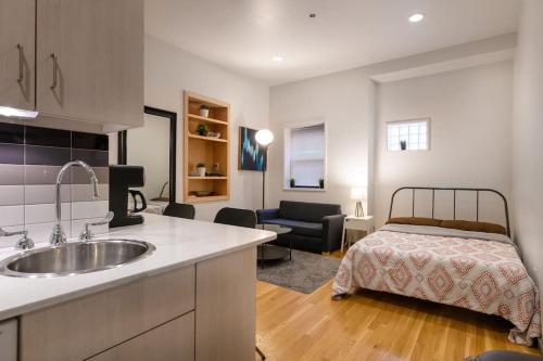 eine Küche mit einem Waschbecken und ein Bett in einem Zimmer in der Unterkunft Modern Studio In City Center, Near Boston Common in Boston