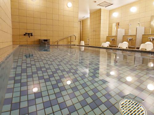 baño con piscina con aseos y espejos en Kuretake Inn Premium Numazu Kitaguchi Ekimae, en Numazu