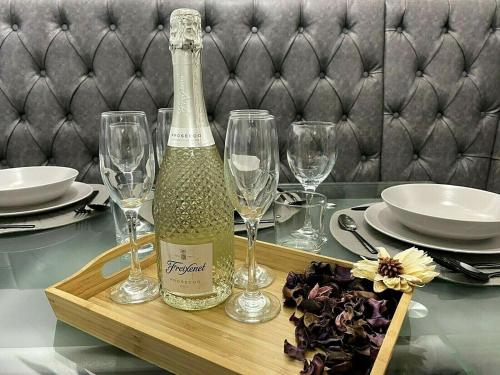 een fles wijn op een tafel met glazen bij ☆Igloo MagnoliaView Luxe Townhouse + Free Parking☆ in Leeds