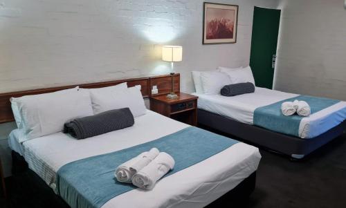 2 letti in camera d'albergo con asciugamani di Seaton Arms Motor Inn ad Albury