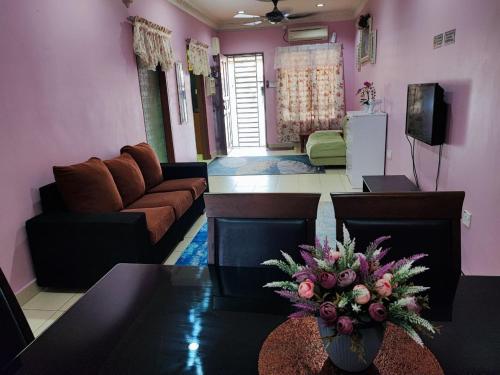 ein Wohnzimmer mit einem Sofa und einem Tisch in der Unterkunft Homestay D'Lily in Ipoh